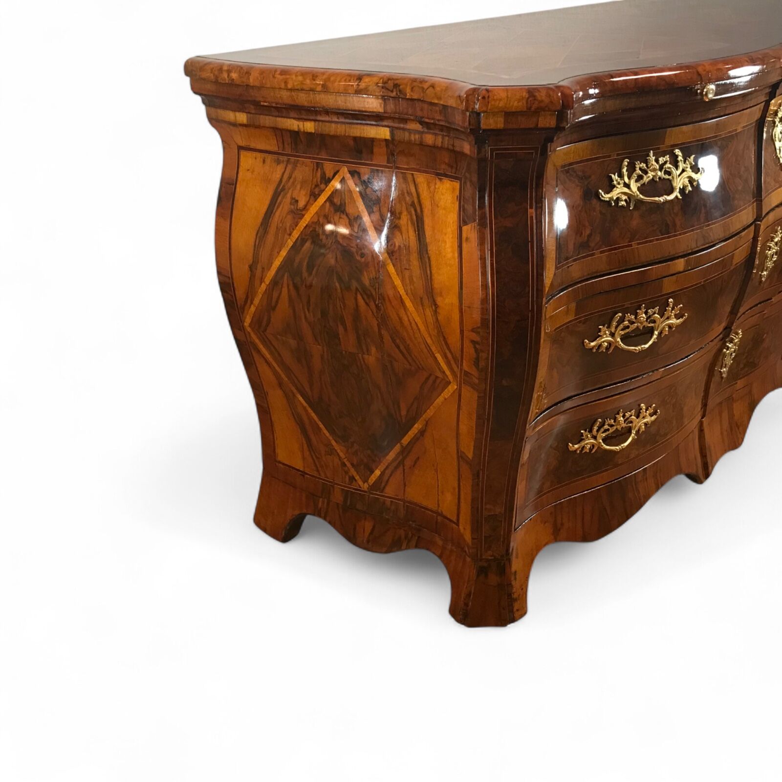 8th century German Baroque chest of drawers, circa 1750, with bombe shape, walnut veneer, intricate marquetry top, root walnut accents, and original ormolu fittings, shown from front-left three-quarter angle- Styylish